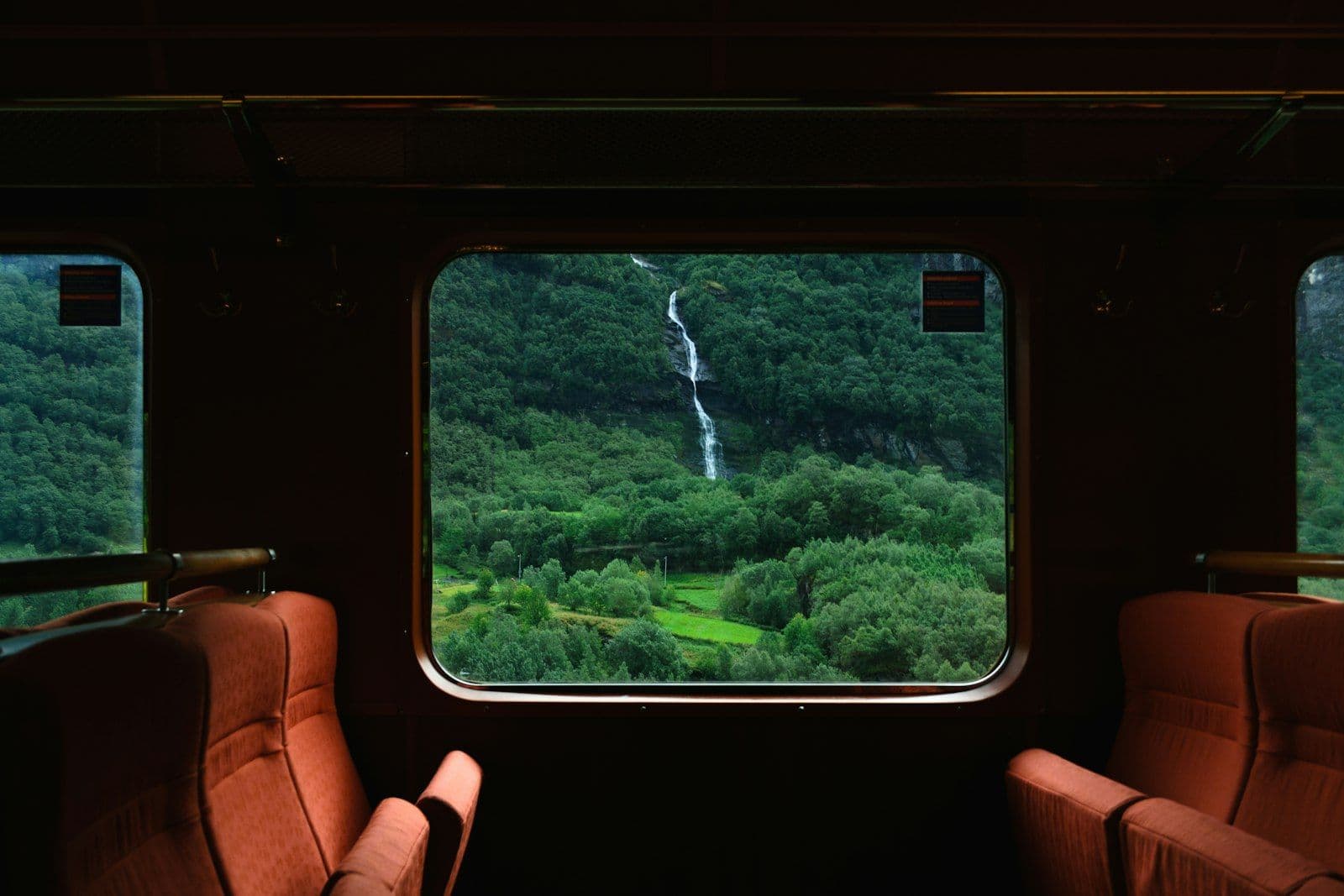 Uitzicht op een waterval door het raam van een trein